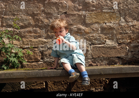 La Newstead Abbey ragazzo di età compresa tra i due si siede su un banco con un drink Foto Stock