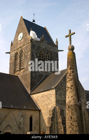 Ste Mère Eglise con un manichino di parachutist John Steele atterrato sulla chiesa steeple durante lo sbarco in Normandia di 1944 Foto Stock