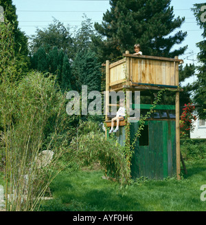 Bambini che giocano sul telaio di arrampicata in paese grande giardino Foto Stock