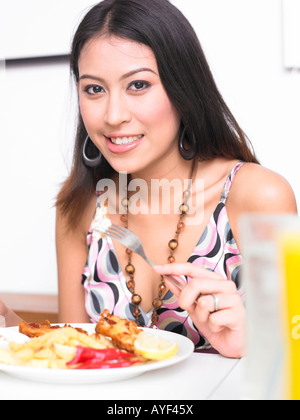 Giovane donna di mangiare al ristorante Foto Stock