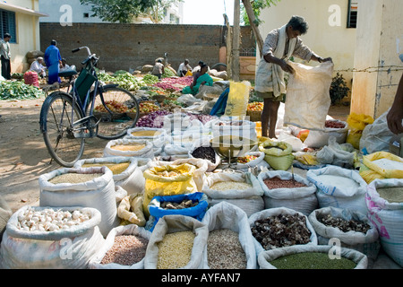 Il mercato indiano uomo vendita di sacchi di cibo e produrre nella città di Puttaparthi, Andhra Pradesh, India Foto Stock