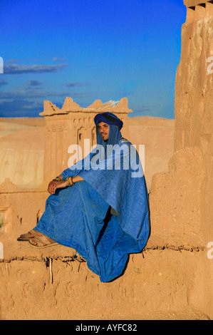 Il Tuareg uomo vestito in abiti tradizionali con Ait Benhaddou Kasbah in background Ouarzazate Marocco Foto Stock