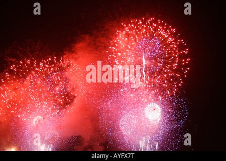 Red fuochi d'artificio che esplodono nel cielo di notte Foto Stock