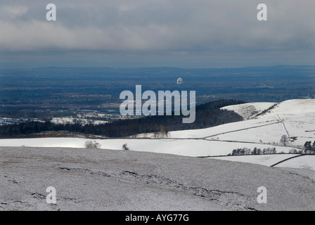 Vista su tutta la pianura del Cheshire dal Cat Fiddle con Jodrell Bank illuminata dal sole nel centro di neve in primo piano Foto Stock