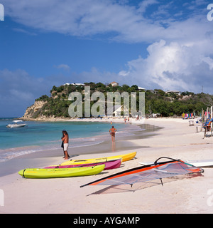 Kayaks colorati e windsurf sulla spiaggia con due uomini a bordo della Long Bay Antigua nei Caraibi Foto Stock