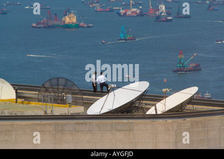 Due uomini in abbigliamento Business Meeting sulla parte superiore di un edificio Highrise Hong Kong Cina Foto Stock