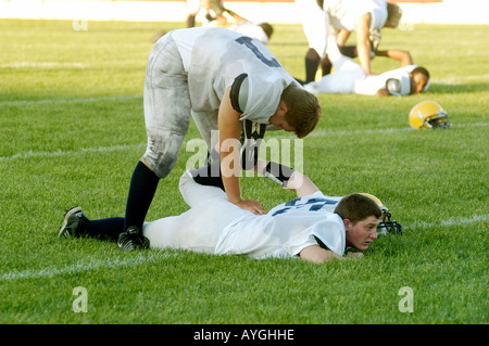 I giocatori di Football warm up con gli esercizi prima di giocare in un gioco Foto Stock