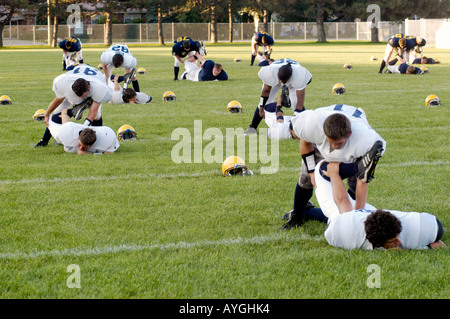 I giocatori di Football warm up con gli esercizi prima di giocare in un gioco Foto Stock