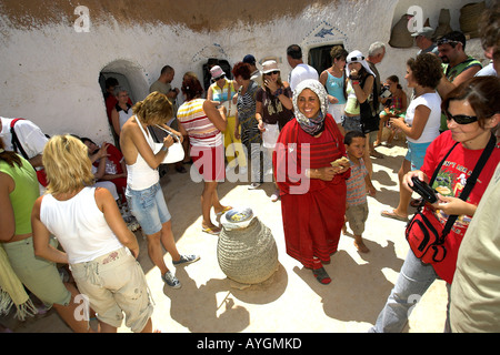 Berber donna intrattiene una folla di visitatori in metropolitana troglodita berbero home Matmata Tunisia Foto Stock