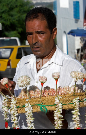 Gelsomino venditore in veste bianca con cappello di paglia Sidi Bou Said village Tunisia Foto Stock