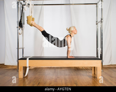 Donna che esercitano sulle attrezzature pilates Foto Stock