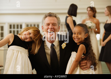 Padre della sposa abbracciando le ragazze di fiori Foto Stock