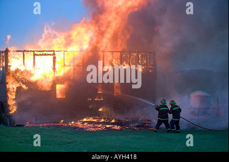 Vigili del fuoco applicare acqua su un edificio in fiamme Foto Stock