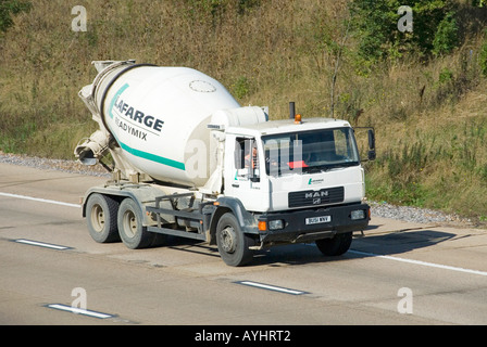 Vista dall'alto di lato e fronte DI UOMO pronto mix cemento betoniera camion camion e conducente gestito da Lafarge business Company su M25 autostrada UK Foto Stock