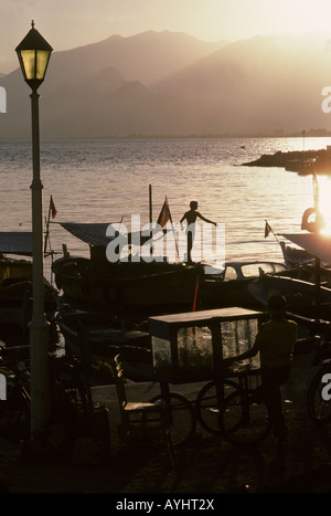 Porto di Antalya, Turchia - Türkiye - con montagne Taurus in lontananza. Un giovane pescatore che si presenta alla luce della sera Foto Stock