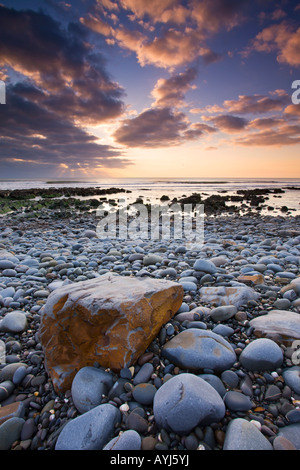 Tramonto sull'Oceano Atlantico dalla rive di ciottoli di Sandymouth Cornwall Inghilterra Foto Stock