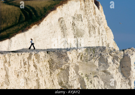 Una giovane donna che cammina su scogliere in Seaford, East Sussex. Foto da Jim Holden Foto Stock