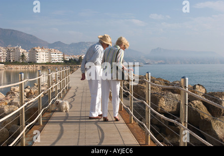 Coppia di anziani con il cane facendo una passeggiata lungomare di Altea, Spagna Foto Stock