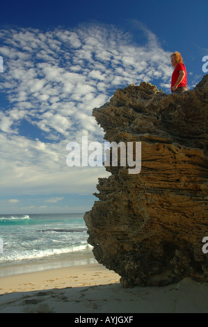 Uomo in camicia rossa guarda il mare Foto Stock