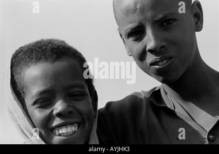 Ritratto B/N di due ragazzi rurali, uno ridendo, l'altro accigliato. Mekoni, Tigray, Etiopia, Africa Foto Stock