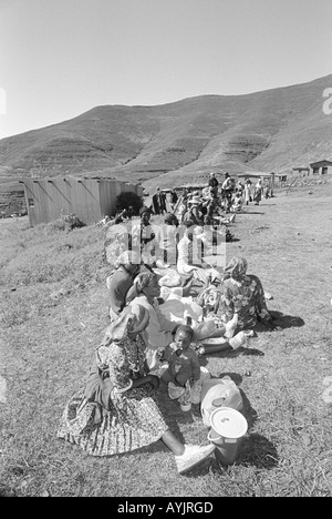 B/N di donne e bambini in attesa di aiuto alimentare in un centro di distribuzione durante un periodo prolungato di siccità in White Hill, Lesotho rurale Foto Stock