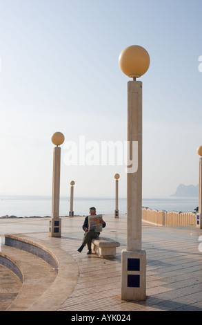 L'uomo la lettura di giornale sul lungomare di Altea, Costa Blanca, Spagna Foto Stock