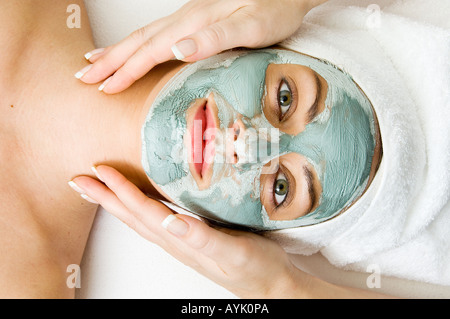 Donna con fango viso pack ricevere massaggi Foto Stock