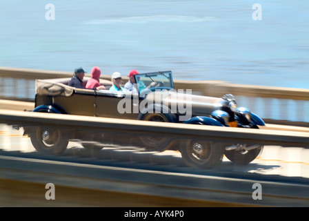 Un gruppo di persone in autovettura vintage viaggiando attraverso Bixby ponte sulla autostrada 1 Pacific Coast Highway vicino Monterey in California Foto Stock