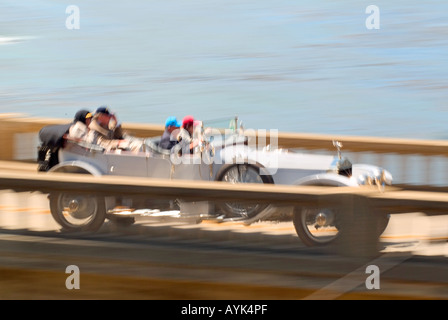 Un gruppo di persone in autovettura vintage viaggiando attraverso Bixby ponte sulla autostrada 1 Pacific Coast Highway vicino Monterey in California Foto Stock