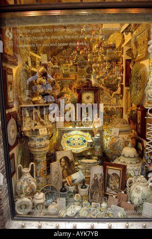 Negozio di souvenir in vendita, affollato di finestra del negozio di ceramiche in Assisi Italia montante verticale verticale Foto Stock