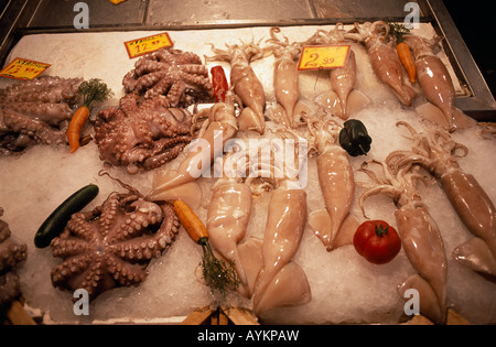 Posa su un letto di ghiaccio Octopus e calamari pesce è visualizzato in vendita nel mercato di Psiri quartiere centrale di Atene in Grecia Foto Stock