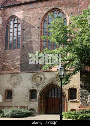 Storico edificio di mattoni a Berlino, con belle finestre ad arco, albero in primo piano entrata ad arco. Foto Stock