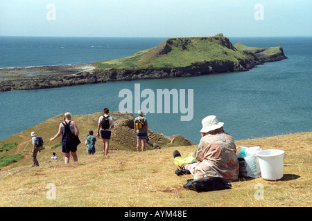 I turisti rilassarsi al sole che si affaccia worm testa sulla costa di Gower vicino a Swansea Wales UK Foto Stock