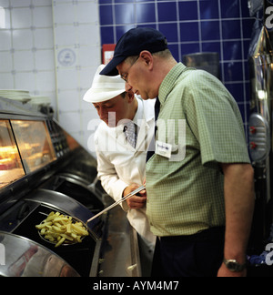 Un ispettore di cibo in un chip shop Foto Stock