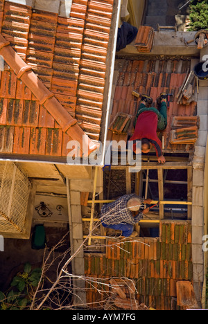 Due conciatetti la riparazione di un tetto di tegole nel sud della Francia. Foto Stock