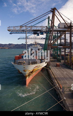 Una nave portacontainer a fianco del dock con gru shore a lavoro, Lyttelton, Nuova Zelanda Foto Stock