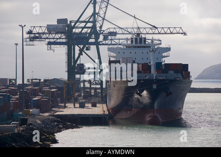 Una nave portacontainer a fianco del dock con gru shore a lavoro, Lyttelton, Nuova Zelanda Foto Stock