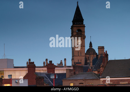 Sole di mattina di catture la torre dell orologio del Municipio Wakefield con camini e tetti di uffici adiacenti in vista Foto Stock