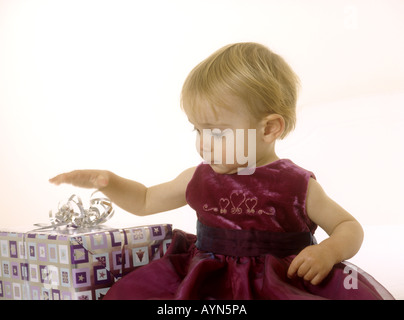 Baby girl apertura di un regalo di Natale Foto Stock