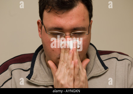 Ritratto di un uomo adulto soffia il naso Foto Stock
