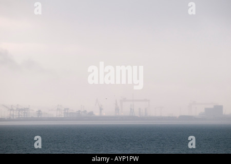 Belfast harbour nei primi giorni di nebbia di mattina con le gru appena visibile Foto Stock
