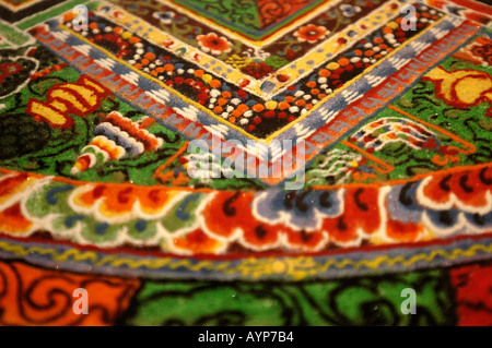Intricato primo piano di un mandala di sabbia buddista tibetano caratterizzato da colori vivaci e dettagliati motivi geometrici nell'arte sacra tradizionale. Foto Stock