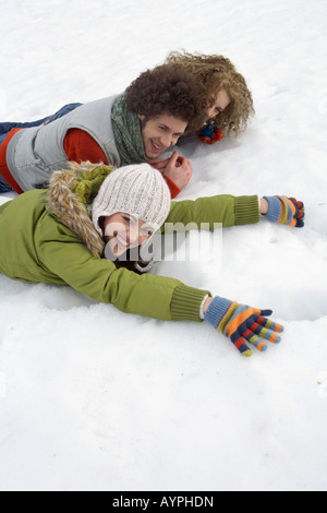 Tre giovani che giace accanto a ogni altro nella neve Foto Stock