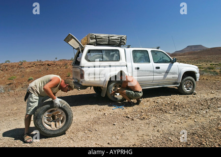 Sostituzione di una ruota su un veicolo fuoristrada (4X4) in Namibia settentrionale, Africa Foto Stock