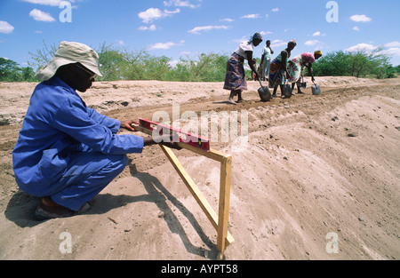 Volontari locali che lavorano su un progetto comunitario di costruzione di diga su piccola scala vicino Binga, Zimbabwe Foto Stock
