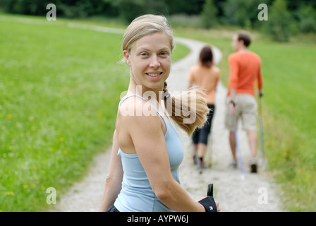 Giovane donna Nordic walking (sci a piedi) dietro un paio Foto Stock