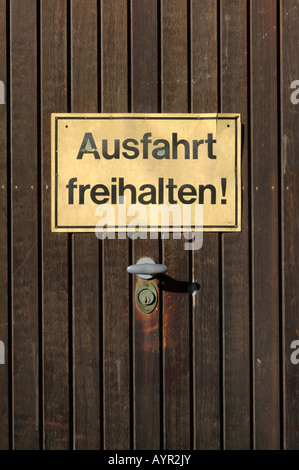 Ausfahrt freihalten (non bloccare l'ingresso) segno inviato su una porta di garage Foto Stock