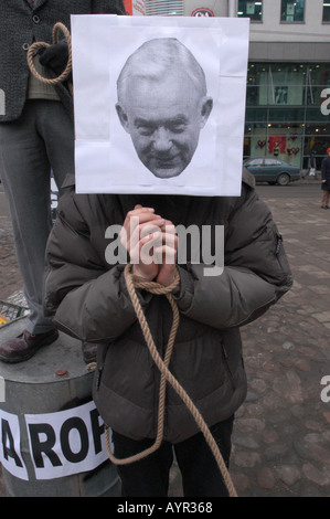 Manifestazione anti-guerra a Poznan in Polonia: Un manifestante con le mani legate e una maschera esprime il dissenso politico in una piazza pubblica. Foto Stock