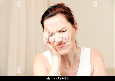 Donna di mezza età tenendo per mano sua fronte Foto Stock