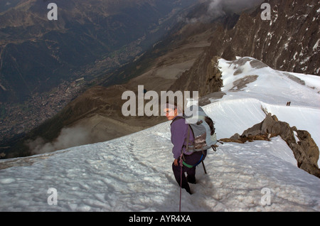 Una cordata lady scalatore scendendo una stretta dorsale nelle Alpi francesi, Chamonix, Francia. Foto Stock